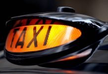 Illuminated taxi sign on a black cab